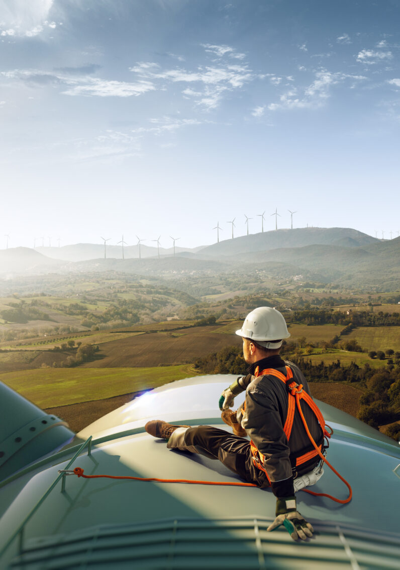 Engineer sits atop a wind turbine