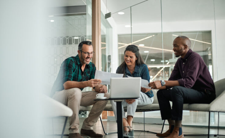 Casual meeting of smiling diverse business team analyzing financial data