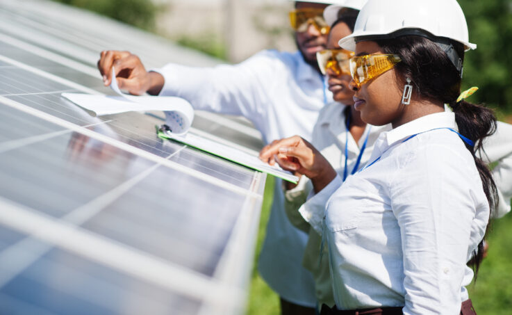 A team of solar panel engineers performing an inspection together in the field