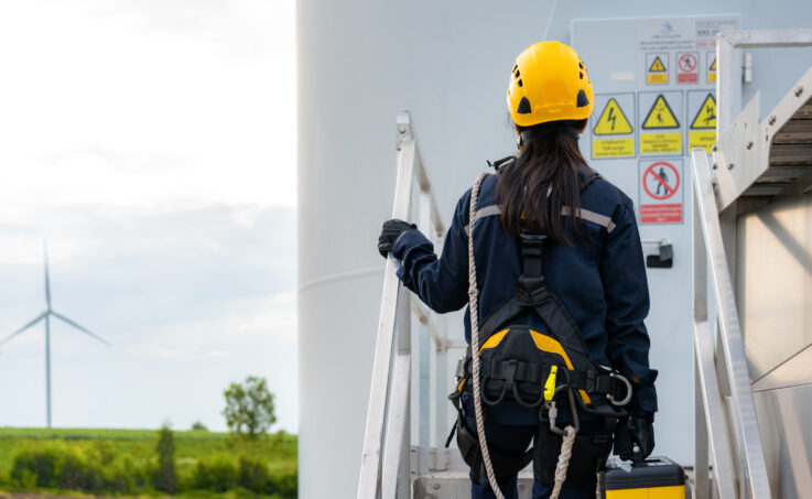 Female Inspection engineer preparing and progress check of a wind turbine with safety in wind farm