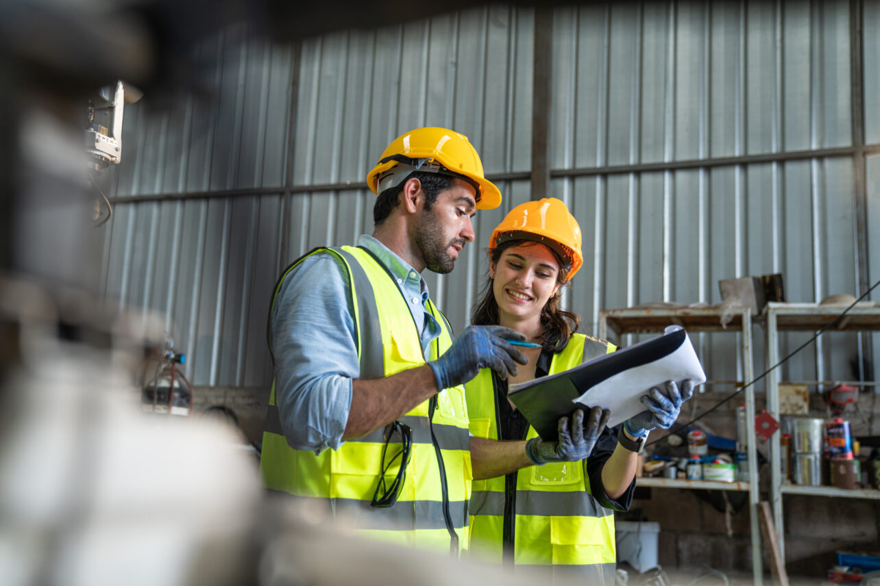 Portrait of a male and female automation engineer working in industrial factory.