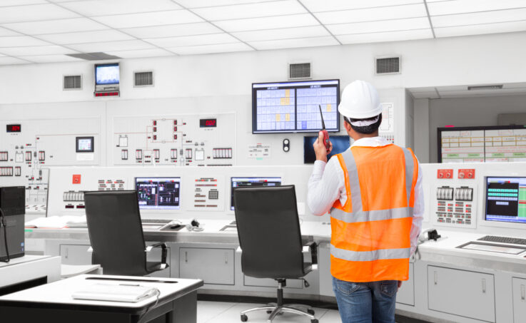 Electrical engineer working in the control room of a modern power generation plant