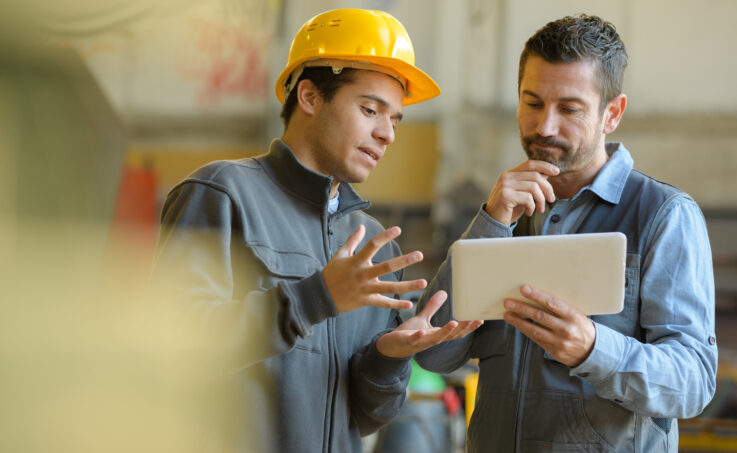 Two workers discussing over a tablet