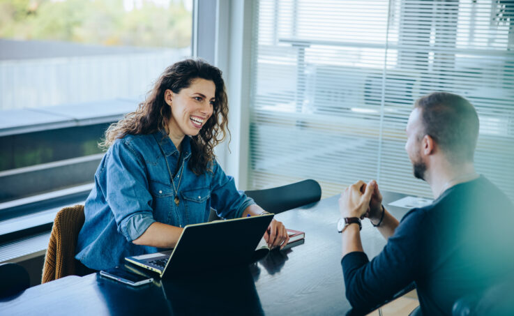 Smiling businesswoman taking interview of a job applicant. 