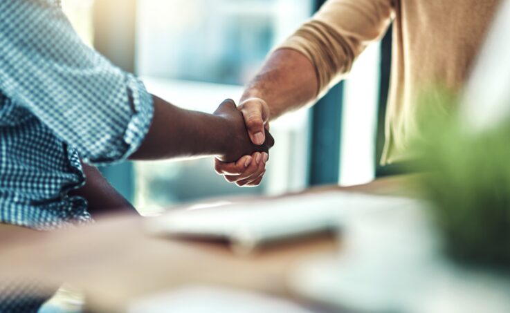 Two people shaking hands in an office