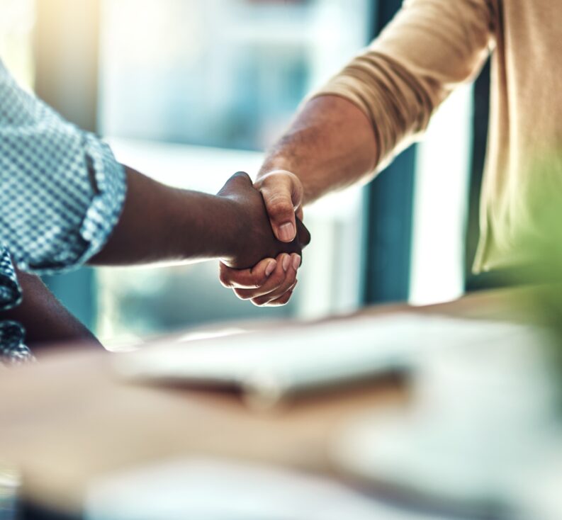 Two people shaking hands in an office