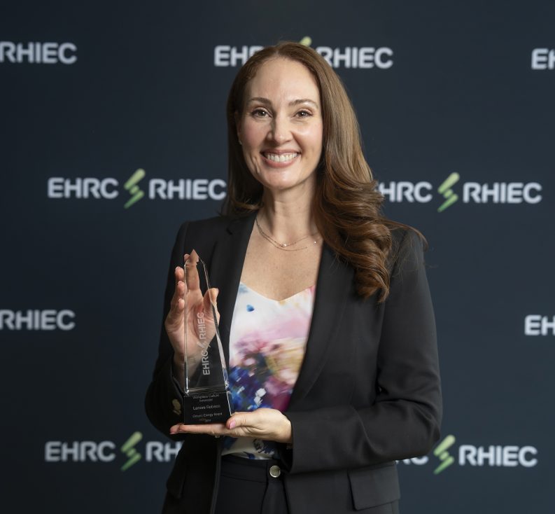 Award recipient smiles and poses with their award
